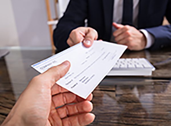 person handing over a check to someone