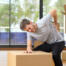 man with back injury from carrying heavy boxes
